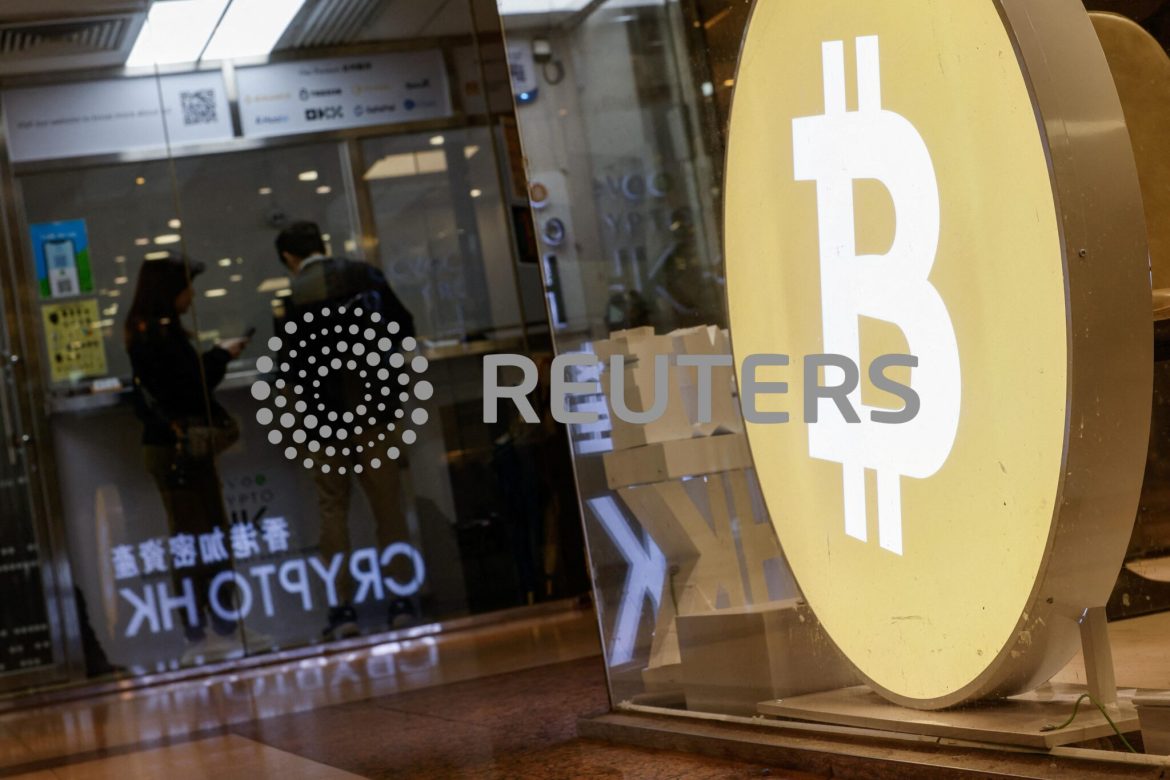 Customers stand at a cryptocurrency exchange store after Bitcoin soars above $100,000, in Hong Kong
